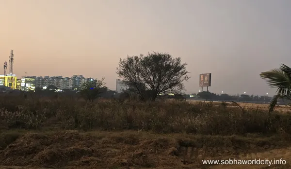 A contemporary multi-story building at Prestige Golden Grove with grey walls, red vertical louvers, and an external staircase seen through trees.